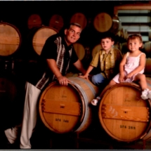 Steve, Cameron and Rebecca Reynolds leaning on barrels