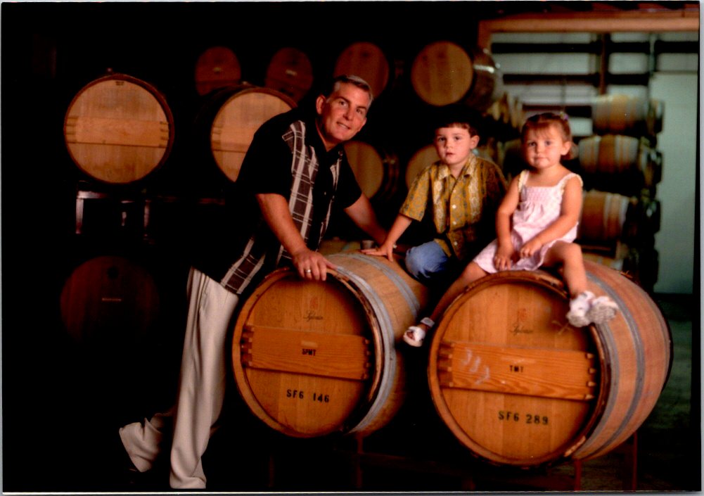 Steve, Cameron and Rebecca Reynolds leaning on barrels