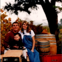 Cameron, Suzie and Steve Reynolds sitting on tractor in vineyards