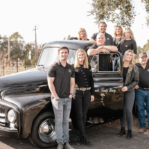 Reynolds Family and Staff Posing by Black Truck